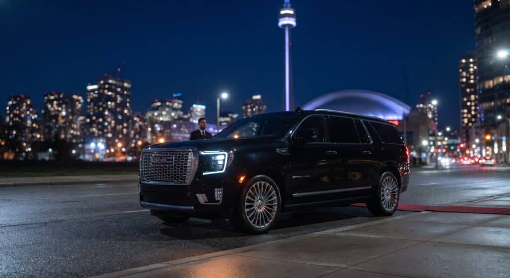 Black GMC Yukon Denali staged for a concert pickup near Rogers Centre and the CN Tower in downtown Toronto