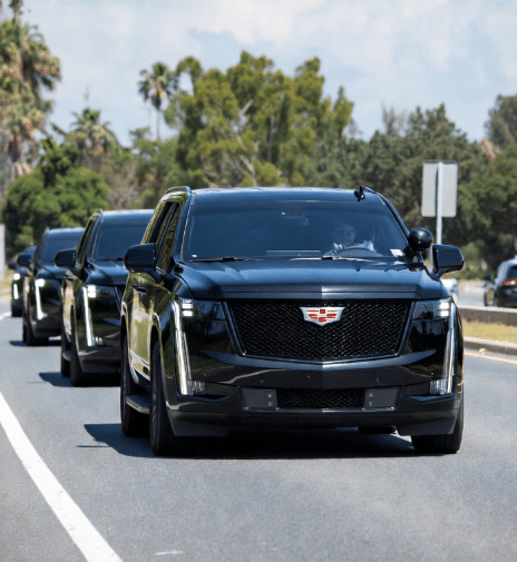 Fleet of unmarked black SUVs staged for a diplomatic delegation departure in downtown Toronto.