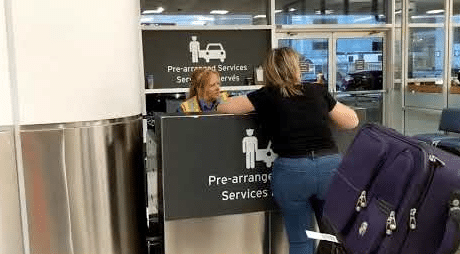 A passenger checking in at the Pre-arranged Services counter at an airport terminal for a limousine pickup