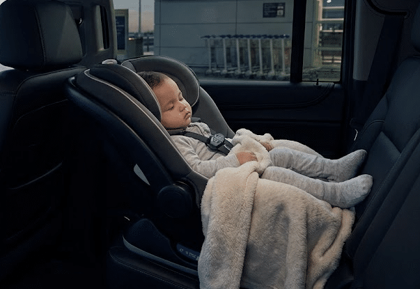 A serene photograph from inside a VVIP Toronto Limo SUV, where an infant sleeps peacefully in a sanitized rear-facing car seat at Toronto Pearson Airport at 3:30 AM.