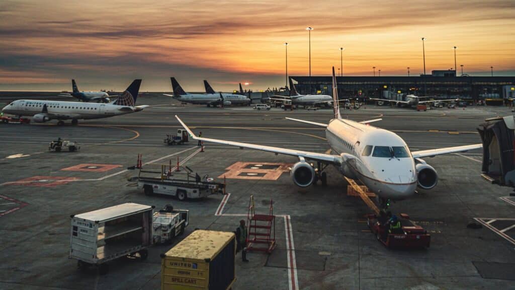 Airplanes parked at airport gates at sunset