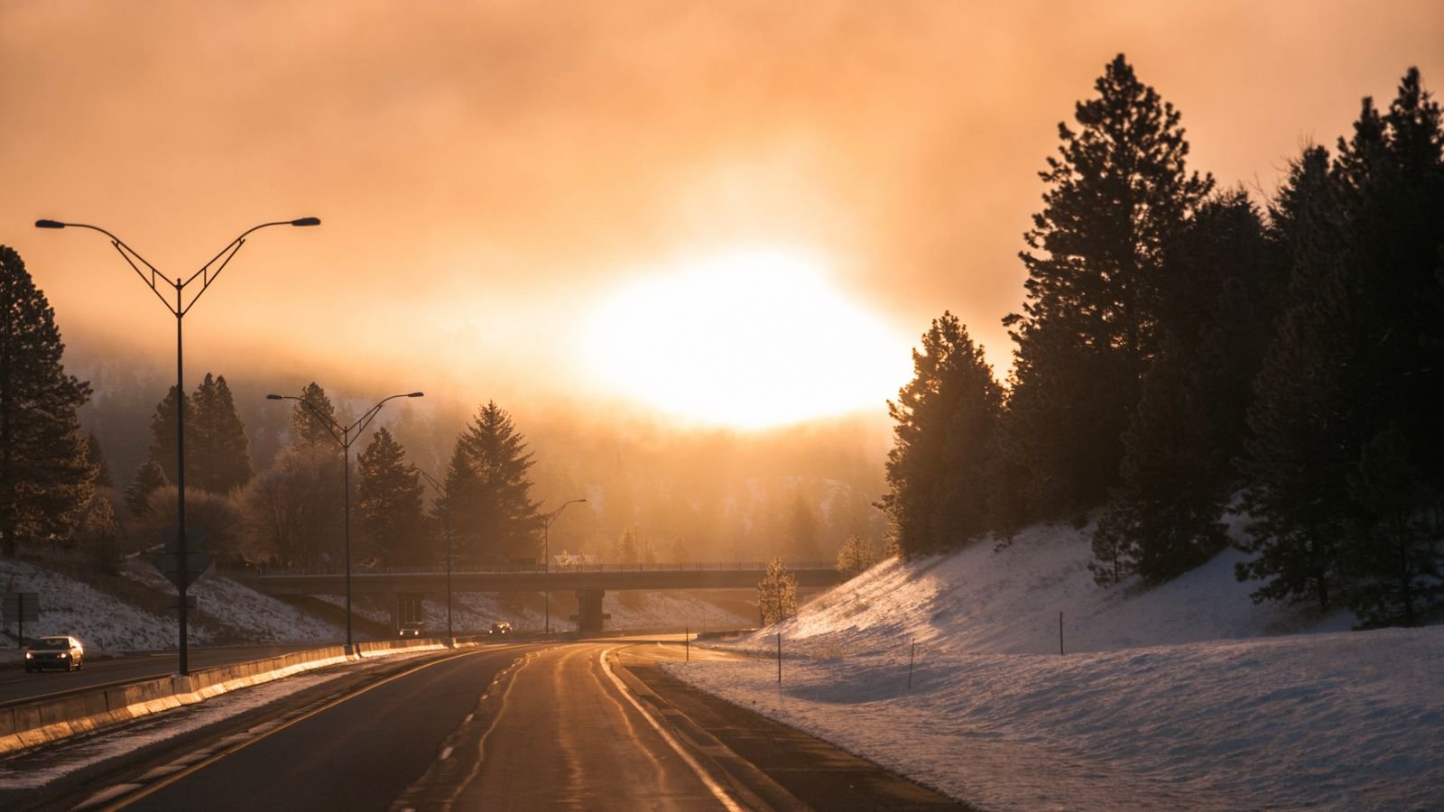 Snowy highway at sunrise in winter
