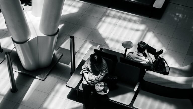 Travellers resting on seats inside an airport terminal
